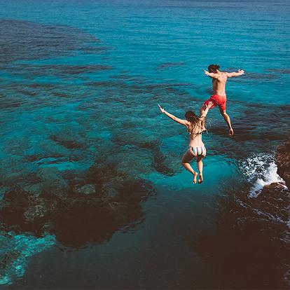 a couple jumping to the sea
