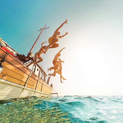a group of friends jumping to the sea
